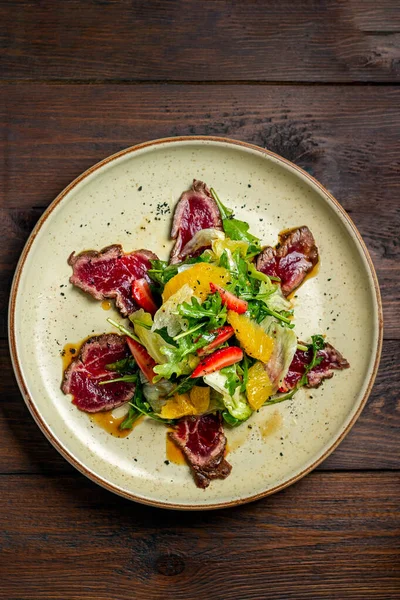 Carpaccio plate on dark wooden table top view — Stock Photo, Image