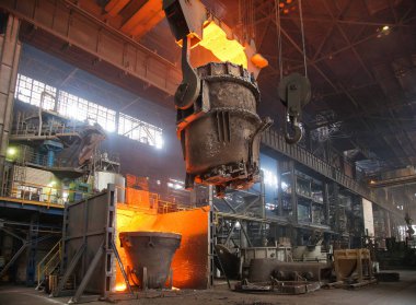 Bir sıcak metal akıntısı kepçeye dökülüyor. Elektrikli ark fırını EAF. Metalürji.