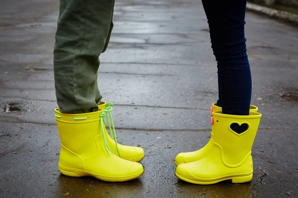 Children in yellow rubber boots. Rainy bow. Clothes for the rain.