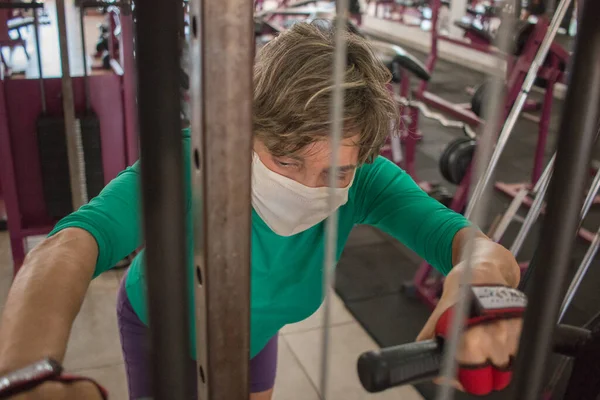 Fit Mature Lady Working out at the Gym wearing a Protective Mask