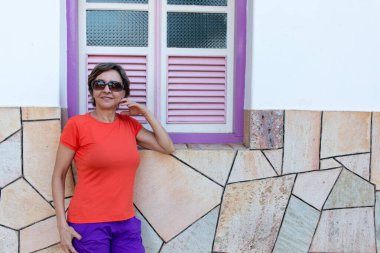 Duvara yaslanmış, penceresi mora bulanmış bir kadın.