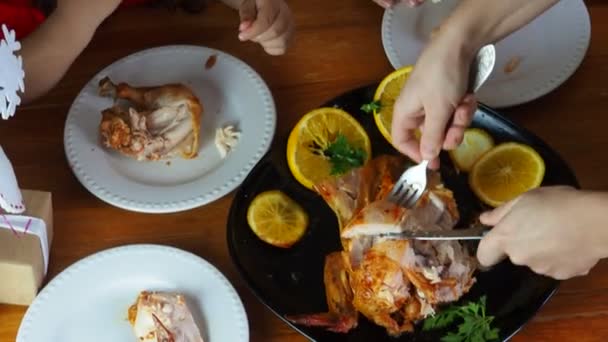 Moeder snijdt kip voor feestelijk diner Thanksgiving dag, Kerstmis of nieuwjaar, kinderen zitten aan de tafel. familie diner, oven gebakken kip, kalkoen curry — Stockvideo