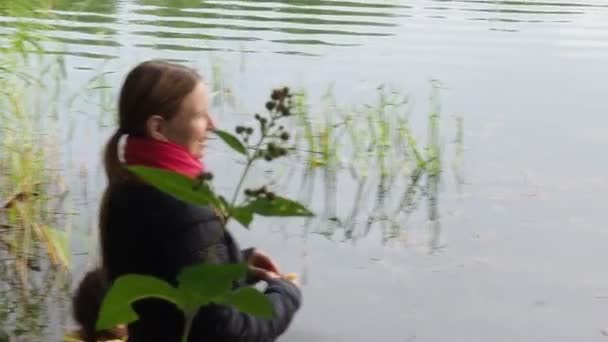 戻るビューの彼女の母親と湖のそばに座っている小さな女の子 — ストック動画