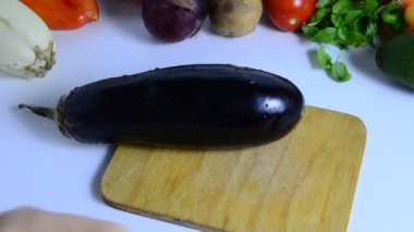 Bıçaklı kadın eli mutfakta patlıcan kesiyor. Sebze pişiriyorum. Sebze yahnisi veya salata yapmak için. vejetaryenlik, diyet, düşük kalori, uygun beslenme