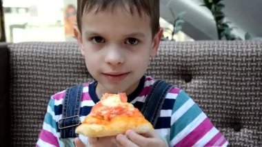 Kafede kutudan pizza yiyen tatlı çocuk.