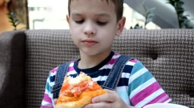 Kafede kutudan pizza yiyen tatlı çocuk.