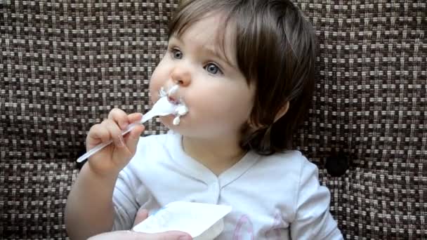 Happy infant baby boy spoon eats itself. baby girl toddler in a cafe feeds itself useful food. porridge, cottage cheese, yogurt spoon — 비디오