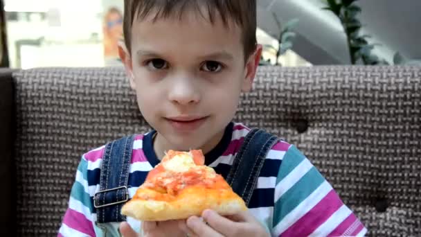 Lindo chico comiendo pizza en la cafetería frome la caja — Vídeo de stock