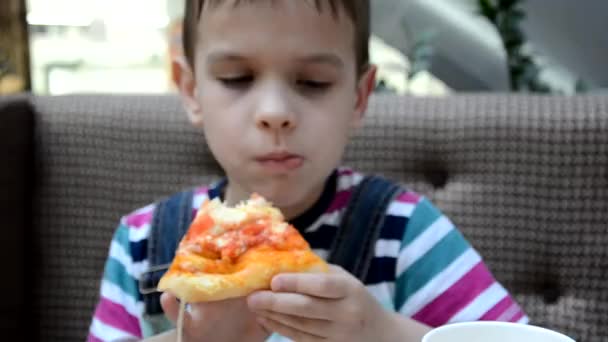 Słodki chłopiec jedząc pizzę w kawiarni z pudełka — Wideo stockowe
