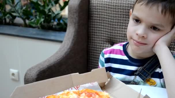 Lindo chico comiendo pizza en la cafetería frome la caja — Vídeos de Stock