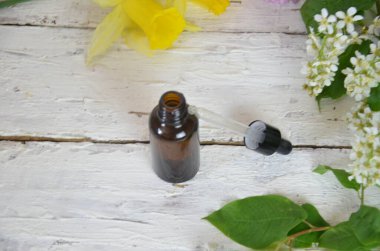 Taze çiçeklerle çevrili gerekli aromatik veya tıbbi yağlardan oluşan şişeler.