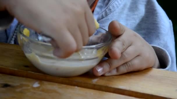 Счастливый мальчик ест хлопья с молоком кукурузы на фоне листьев на завтрак — стоковое видео