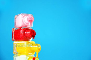 Mavi arka planda dökülmüş ojeli şişeler moda, güzellik, kadınların ilgisi. Manikür. Güzellik salonu. spa