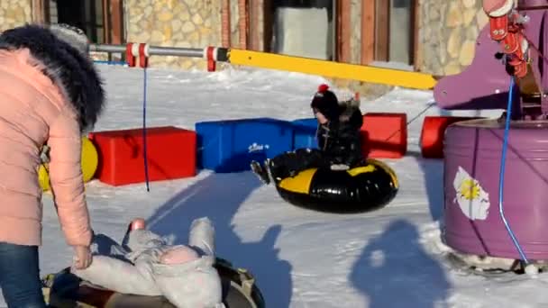 Vinternöje, snö, glada barn pulka på vintern. Mor, sol och småbarn — Stockvideo