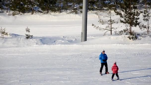 Přeplněné turisty baví aktivity Lesní lyžařské středisko. Lidé sjíždějí ze svahů na lyžích a snowboardu. Horské lyžařské středisko. zimní sporty — Stock video