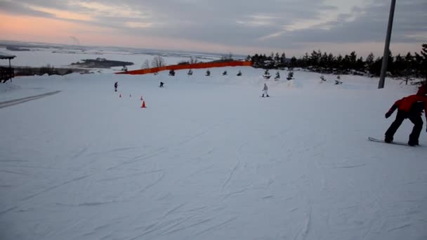 Přeplněné turisty baví aktivity Lesní lyžařské středisko. Lidé sjíždějí ze svahů na lyžích a snowboardu. Horské lyžařské středisko. zimní sporty — Stock video