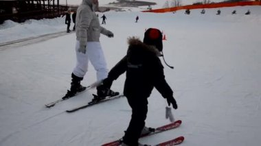 Yüksek dağlarda kayak yapan kayakçı gün ışığına karşı. Anne ve oğlu dağ kayağı yapmayı öğreniyor. Kış sporu. Açık hava