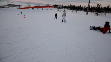 Forest Ski Resort etkinliklerinin tadını çıkaran turist kalabalığı. İnsanlar kayak ve snowboard yaparken yokuş aşağı kayıyor. Dağ kayak merkezi. kış sporları