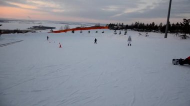 Forest Ski Resort etkinliklerinin tadını çıkaran turist kalabalığı. İnsanlar kayak ve snowboard yaparken yokuş aşağı kayıyor. Dağ kayak merkezi. kış sporları