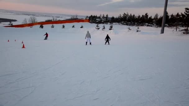 Přeplněné turisty baví aktivity Lesní lyžařské středisko. Lidé sjíždějí ze svahů na lyžích a snowboardu. Horské lyžařské středisko. zimní sporty — Stock video