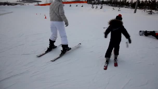 Толпы туристов наслаждаются мероприятиями Forest Ski Resort. Люди катаются на лыжах и сноуборде по склонам. Горнолыжный курорт. зимний спорт — стоковое видео