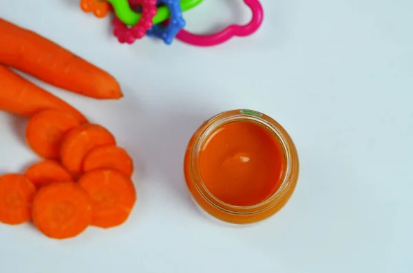 Purè di bambino con cucchiaio in vaso di vetro su sfondo bianco — Foto Stock