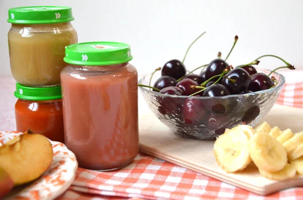 Comida para bebés, fruta del bebé triturada en un frasco de vidrio, rodajas de plátano, manzana, — Foto de Stock