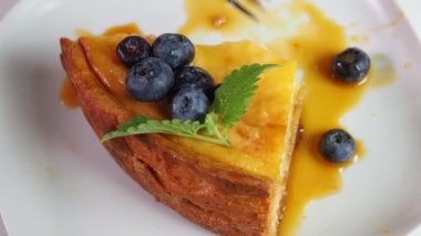 Kapalı kapılar ardında kremalı mascarpone peynirli kek yaban mersinli ve kış meyveli kek yiyen bir kız. New York peynirli keki. Kapatın. Noel tatlısı. Sağlıklı yiyecekler. Yaratıcı atmosfer dekorasyonu.