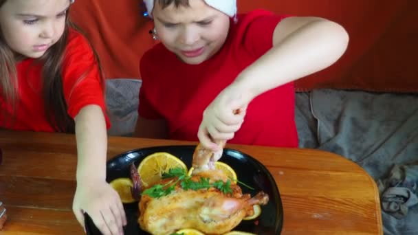 Mom cuts chicken for festive dinner thanksgiving day, christmas or new year, children sit at the table. family dinner, oven baked chicken, turkey curry — Stock Video