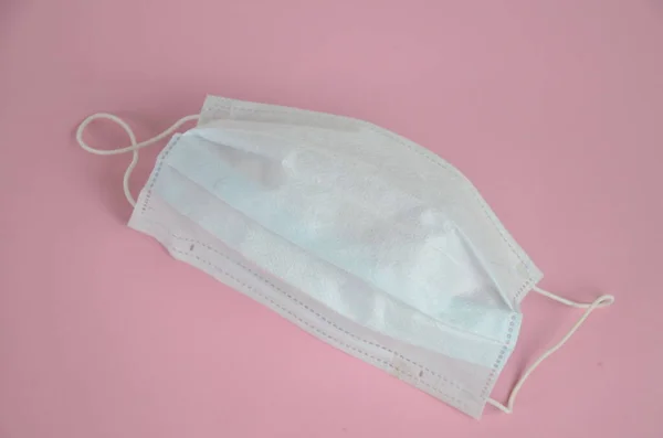 Surgical mask with rubber ear straps. Typical 3-ply surgical mask to cover the mouth and nose. Procedure mask from bacteria. Protection concept.