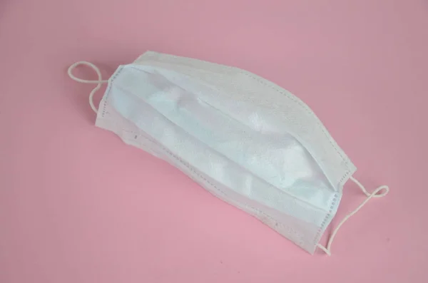 Surgical mask with rubber ear straps. Typical 3-ply surgical mask to cover the mouth and nose. Procedure mask from bacteria. Protection concept.