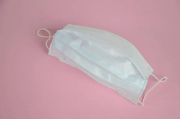 Surgical mask with rubber ear straps. Typical 3-ply surgical mask to cover the mouth and nose. Procedure mask from bacteria. Protection concept.