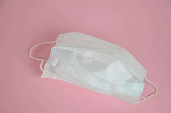 Surgical mask with rubber ear straps. Typical 3-ply surgical mask to cover the mouth and nose. Procedure mask from bacteria. Protection concept.