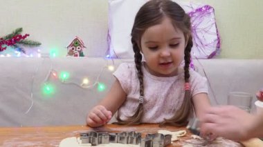 Mutlu Noeller ve mutlu tatiller. Aile hazırlığı bayram yemeği. Anne ve kızı Noel kurabiyesi pişiriyor..