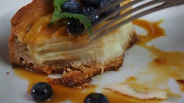 Kapalı kapılar ardında kremalı mascarpone peynirli kek yaban mersinli ve kış meyveli kek yiyen bir kız. New York peynirli keki. Kapatın. Noel tatlısı. Sağlıklı yiyecekler. Yaratıcı atmosfer dekorasyonu.