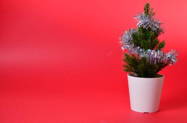 Kırmızı üzerine küçük Noel ağacı süslemeleri. Noel ağacının dalları. Noel veya yeni yıl alışverişi kavramı.