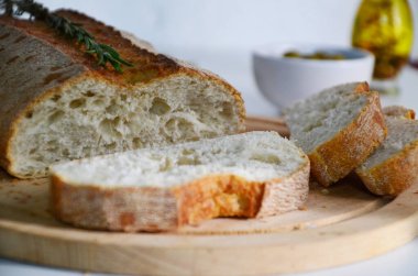 Dilimlenmiş ekmek Ciabatta ve beyaz arka planda ahşap biberiye
