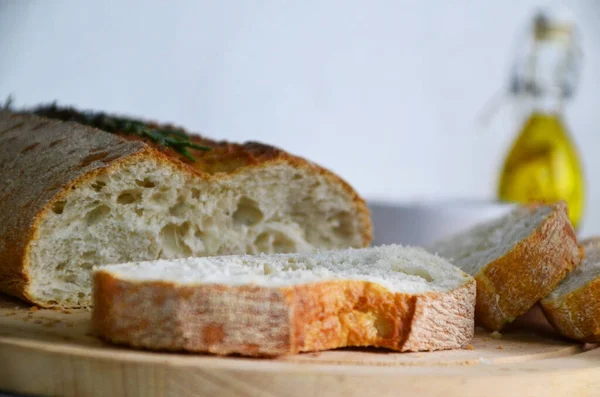 Pão fatiado Ciabatta e alecrim em madeira sobre fundo branco — Fotografia de Stock