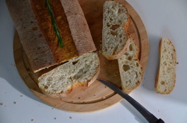 Dilimlenmiş ekmek Ciabatta ve beyaz arka planda ahşap biberiye