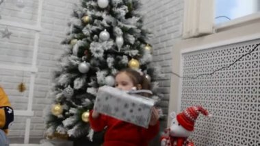 Mutlu küçük çocuklar Noel ağacını geleneksel şömineyle süslerler. Çocuklar Noel arifesinde hediyeleri açıyor. Hediyeleri açmak, yeni yıl oyuncaklarıyla oynamak.