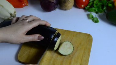 Bıçaklı kadın eli mutfakta patlıcan kesiyor. Sebze pişiriyorum. Sebze yahnisi veya salata yapmak için. vejetaryenlik, diyet, düşük kalori, uygun beslenme