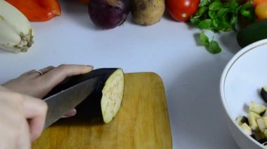Bıçaklı kadın eli mutfakta patlıcan kesiyor. Sebze pişiriyorum. Sebze yahnisi veya salata yapmak için. vejetaryenlik, diyet, düşük kalori, uygun beslenme