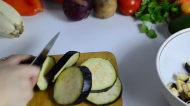Bıçaklı kadın eli mutfakta patlıcan kesiyor. Sebze pişiriyorum. Sebze yahnisi veya salata yapmak için. vejetaryenlik, diyet, düşük kalori, uygun beslenme