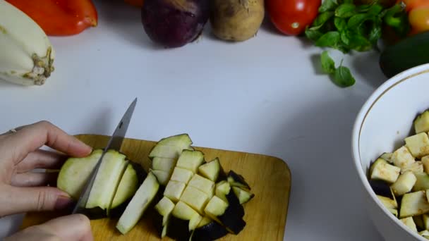ナイフで女性の手は台所でボード上のナスをカットします。野菜料理。野菜のシチューやサラダを作ることです。菜食低カロリー適切な栄養 — ストック動画