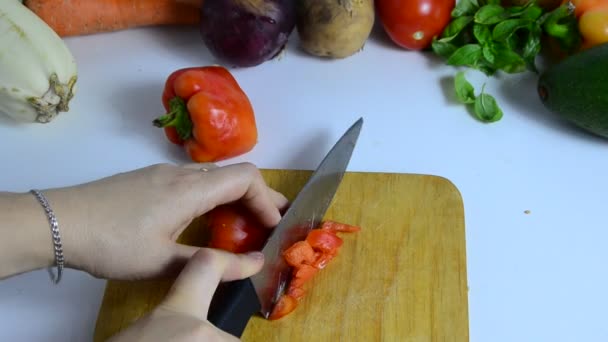 Female hand with knife cuts red sweet pepper on board in kitchen. Cooking vegetables. to make a vegetable stew or salad. vegetarianism, diet, low calories, proper nutrition — Stock Video