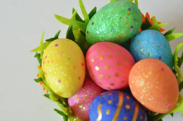 Frohe Ostern. Ostereier-Konzept. Nahaufnahme Bunte Ostereier in Nest und Korb grün krass auf weißem Holzhintergrund. — Stockfoto