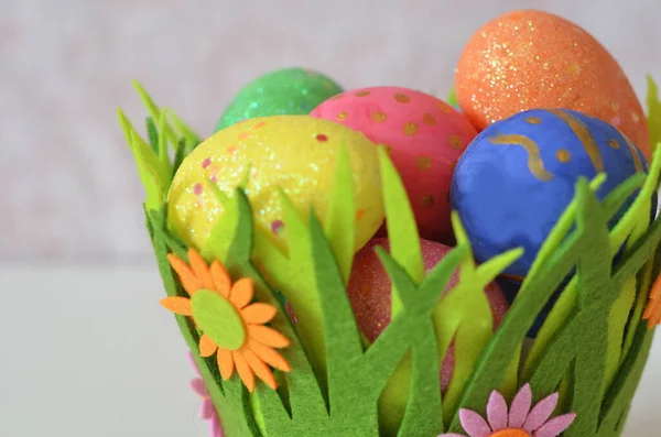 Frohe Ostern. Ostereier-Konzept. Nahaufnahme Bunte Ostereier in Nest und Korb grün krass auf weißem Holzhintergrund. — Stockfoto