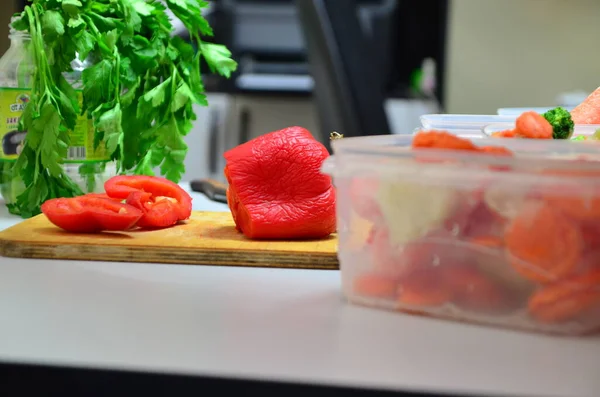 Penutup tangan koki memasak memotong sayuran paprika merah di atas meja kayu dan menaruhnya dalam kotak untuk membekukan — Stok Foto