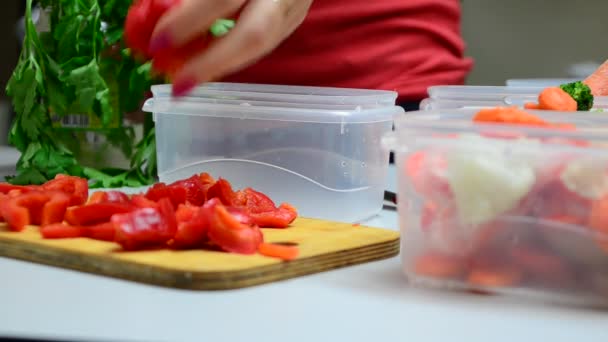 Close-up van de handen van chef-kok snijden rode paprika groenten op houten tafel zet in een doos om te bevriezen — Stockvideo