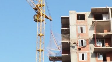 İnşaat halindeki birçok uzun bina ve mavi gökyüzü altında vinçlerle çalışmak.
